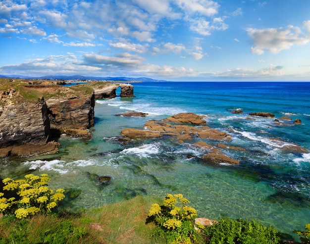 Floreciente paisaje de verano de la costa cantábrica con pintoresco cielo azul (Playa de las Catedrales, Lugo, Galicia, España).