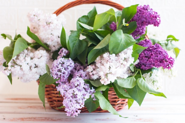 Un floreciente ramo de lilas en una cesta de mimbre Lila multicolor