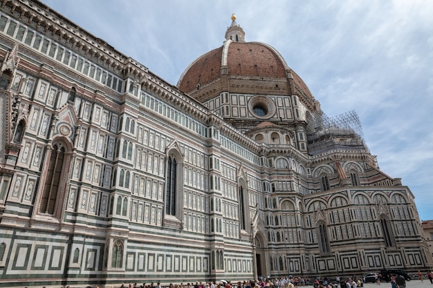 Florença, Itália - 24 de junho de 2018: Vista panorâmica da Cattedrale di Santa Maria del Fiore (Catedral de Santa Maria da Flor) e o Campanário de Giotto. As pessoas andam na praça no dia de verão