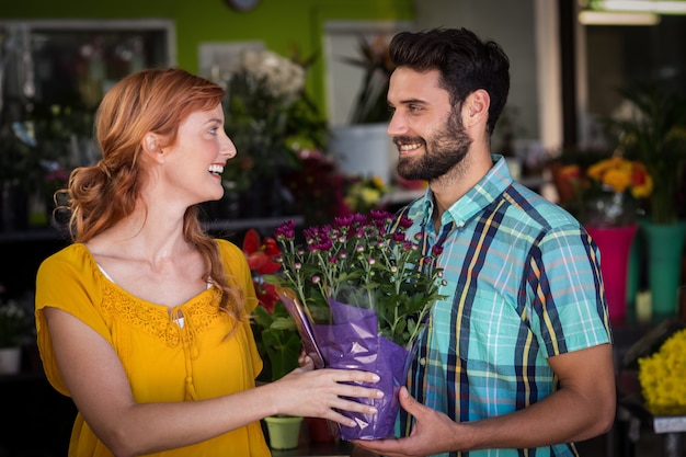 Floreria femenina dando ramo de flores al hombre