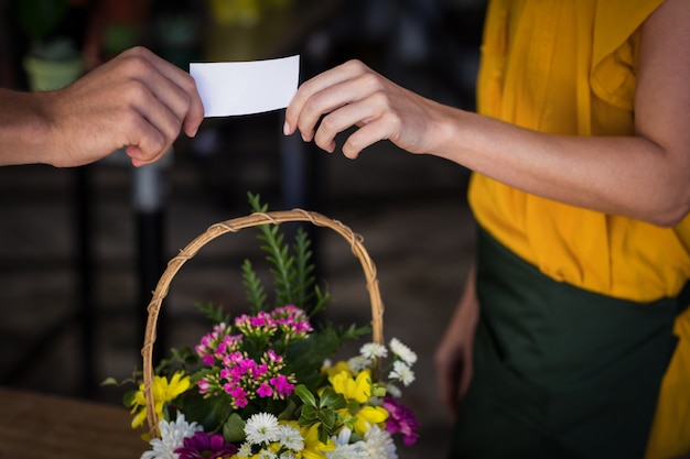 Floreria femenina dando tarjeta de visita al cliente