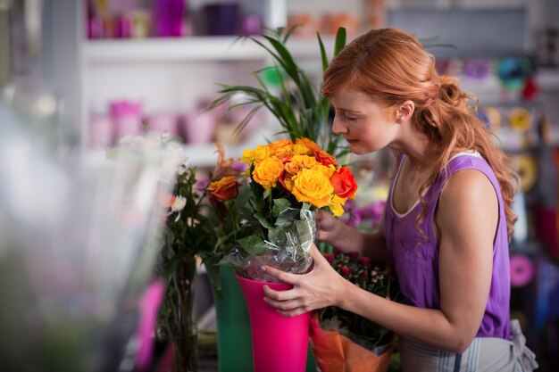 Floreria femenina que huele el ramo de flores