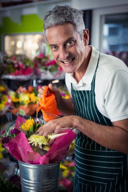 Floreria masculina regando flores con regadera