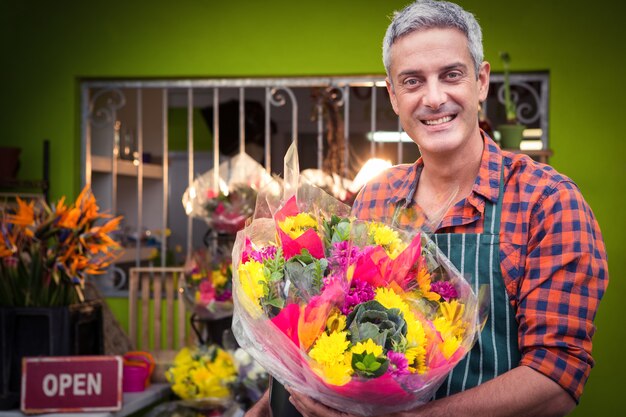 Foto floreria masculino con ramo de flores en florería