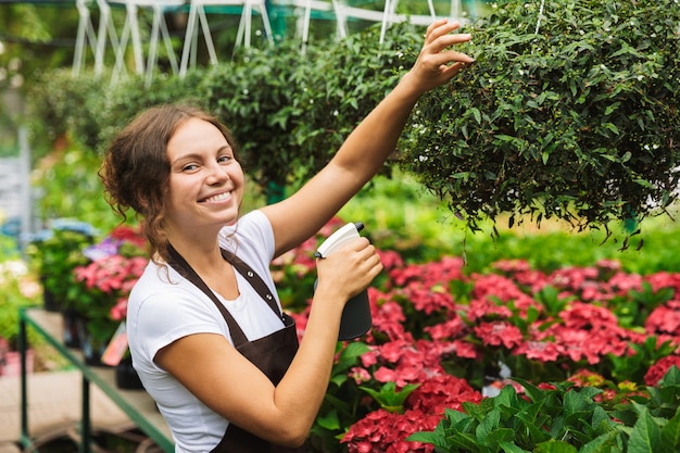 Floreria mujer trabajando en invernadero sobre plantas