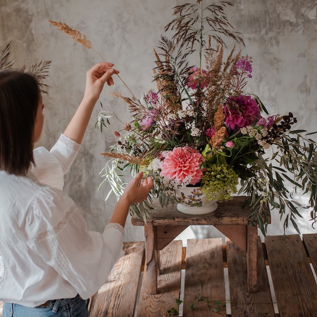 Foto floreria profesional femenina prepara el arreglo de flores silvestres