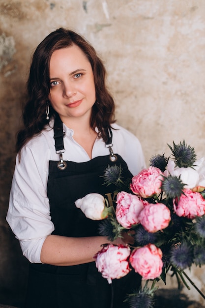 Floreria profesional mujer en su estudio con flores en las manos