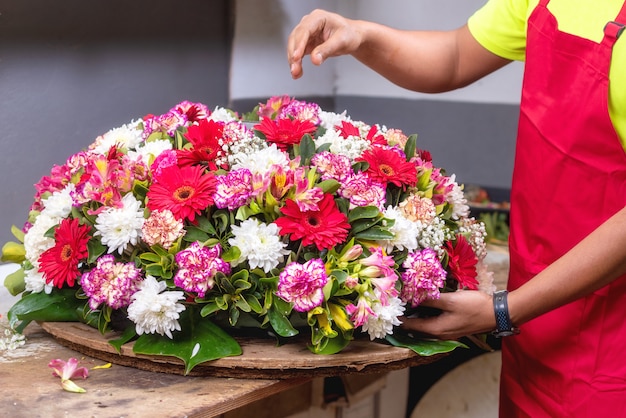 Foto floreria en el trabajo. florista de sexo masculino que crea el ramo hermoso en la floristería.