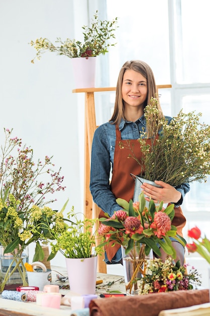 Floreria en el trabajo la joven haciendo moda moderno ramo de flores diferentes