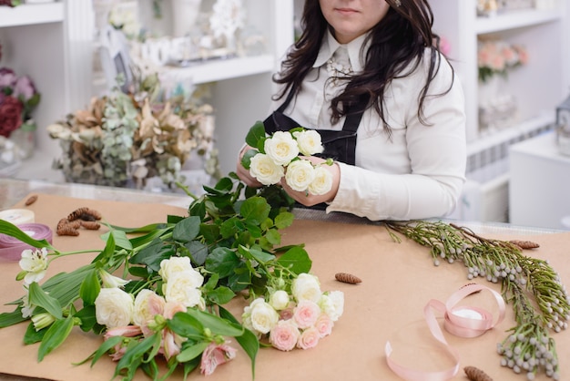 Floreria en el trabajo: mujer arreglando ramo de flores en su espacio de trabajo
