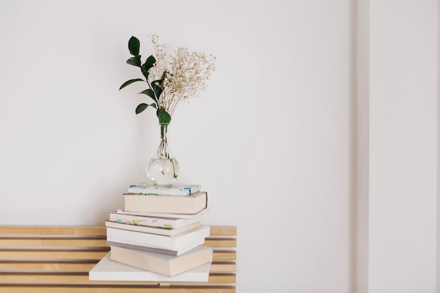 Foto florero con flores en libros