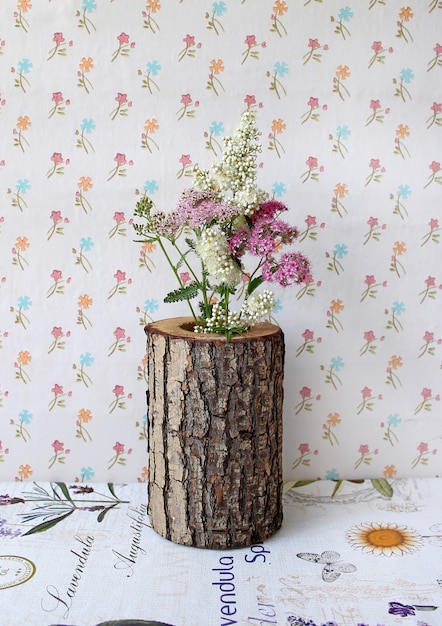 Florero de madera con flores.