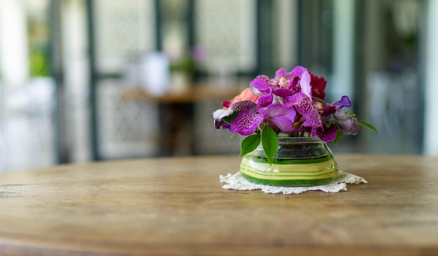 Florero de orquídeas en mesa de madera