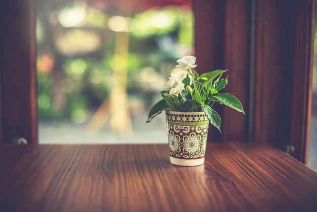 Florero sobre la mesa junto a la ventana