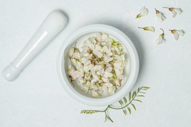 Flores de acacia frescas en el tarro cosmético cosmético casero