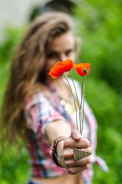 Flores de amapola en manos de mujeres