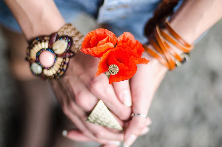 Foto flores de amapola en manos de mujeres