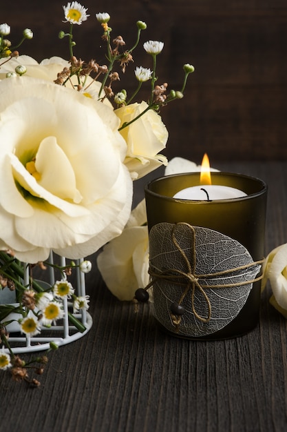 Flores amarelas de lisianthus e vela acesa