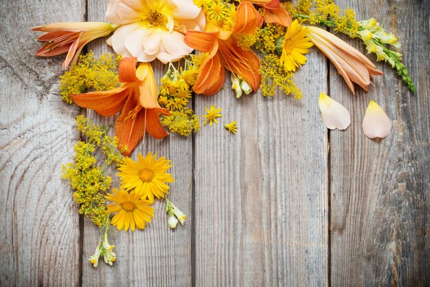 Flores amarelas e laranja em madeira velha