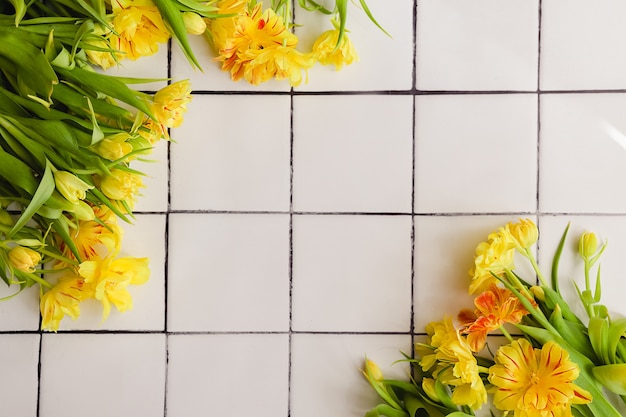 Flores amarillas sobre un fondo de piso de baldosas blancas