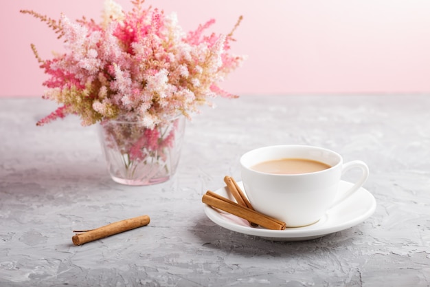 Flores astilbe rosadas y rojas y una taza de café