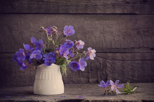 Flores azules en la mesa de madera vieja