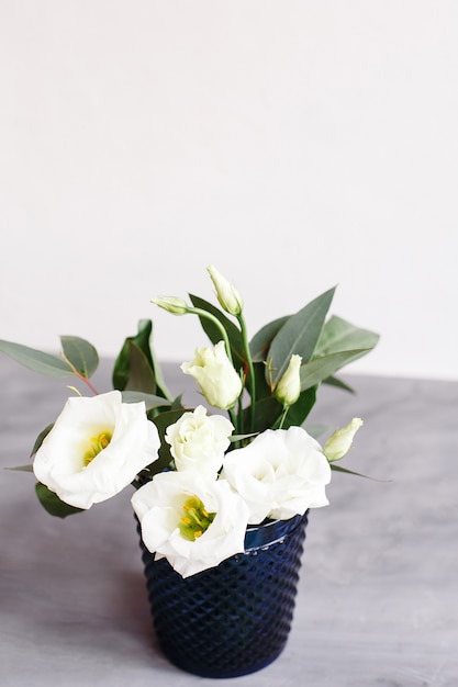 Flores blancas en cristal azul clásico. Lisianthus. Eustoma.