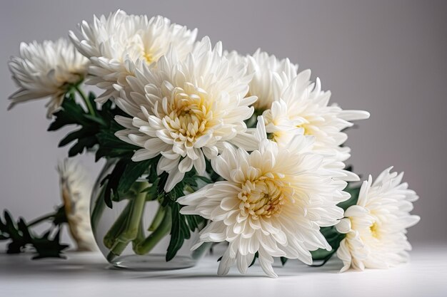 Flores blancas en un jarrón sobre una mesa blanca y fondo gris