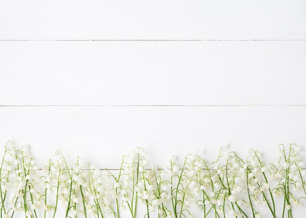 Foto flores blancas sobre un fondo blanco de madera