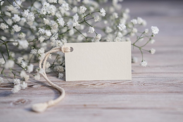 Flores blancas y tarjeta blanca en blanco para texto Etiqueta de maqueta Postal