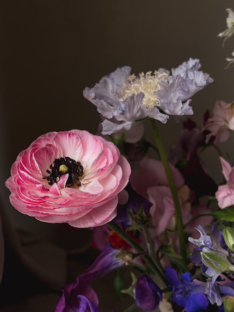 Flores Bodegón Hermosas flores de colores de cerca sobre fondo de mal humor Elegante composición artística de lathyrus anemone ranunculus delphinium Fondo de pantalla floral vertical