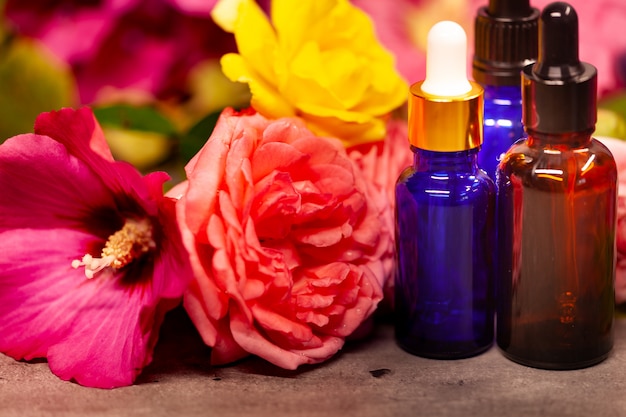 Flores y botellas de aceites esenciales para aromaterapia.