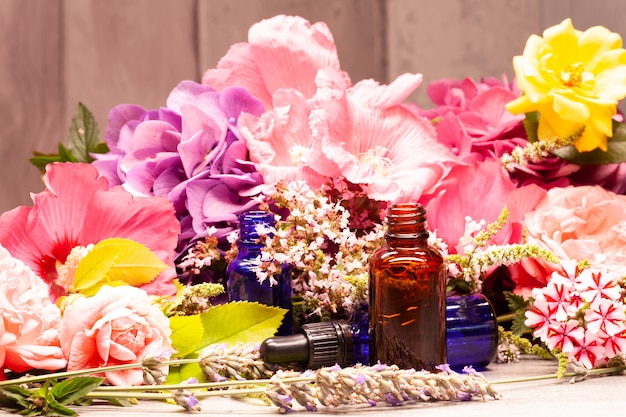 Flores y botellas de aceites esenciales para aromaterapia.