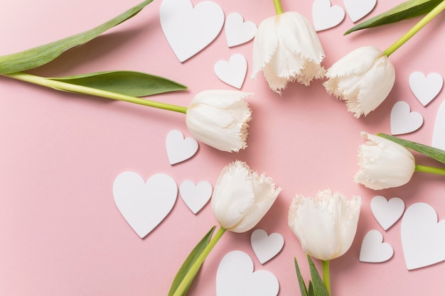 Flores brancas e corações em um fundo rosa pastel