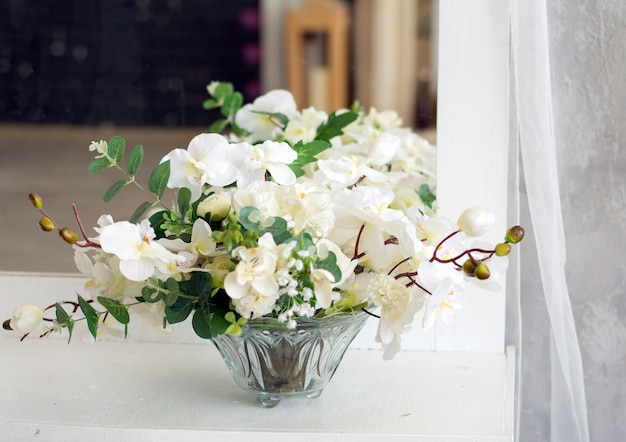 flores brancas em um vaso de vidro sobre a mesa