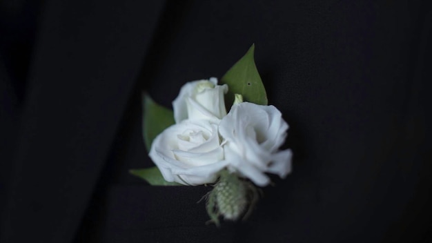 Foto flores brancas no bolso do casaco. o noivo ajusta a mão no bolso do casaco.