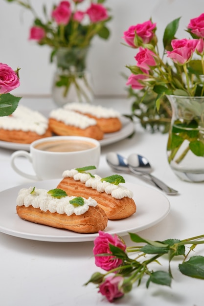 Flores y canutillos decorados con crema y menta sobre una mesa blanca. Postre para una cita romántica. Tortas para las vacaciones.