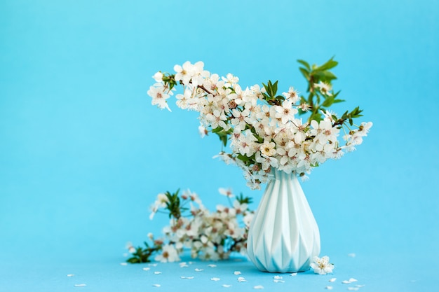 Flores de cerezo en florero azul sobre azul