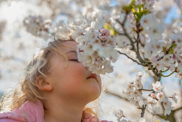 Flores de cerezo. la niña disfruta del aroma de las flores de sakura japonesas. flor de cerezo en japón en primavera.