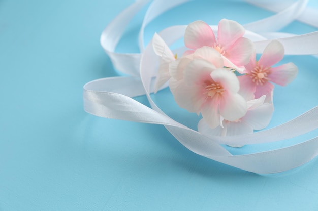 Flores con cinta blanca sobre un fondo azul.