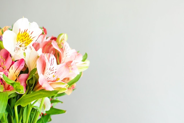 Flores de colores en un jarrón de cemento sobre una mesa de madera