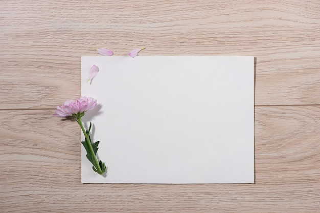 Foto flores cor de rosa e papel vazio para o seu texto em fundo de madeira