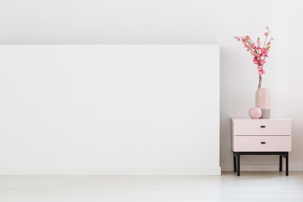 Flores cor de rosa no armário ao lado da parede branca com espaço de cópia em li