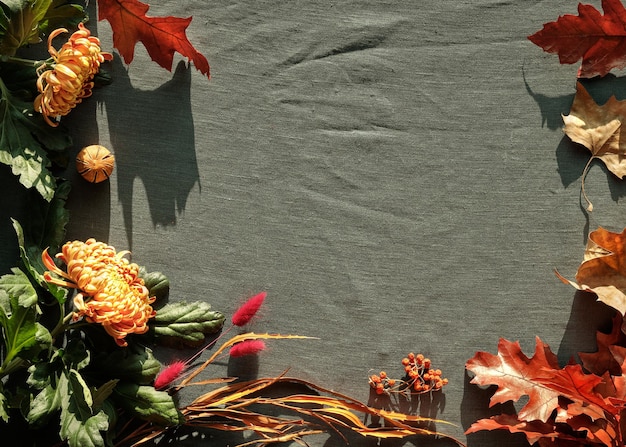 Flores de crisantemo naranja seco cola de conejo hierba y hojas de roble rojo decoraciones de otoño vista superior