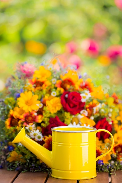 Foto flores da primavera e regador ao ar livre