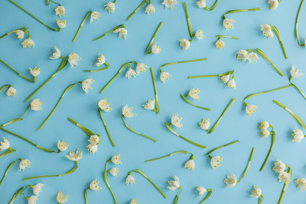 Flores da primavera em papel azul plano dia da terra e conceito ecológico olá primavera