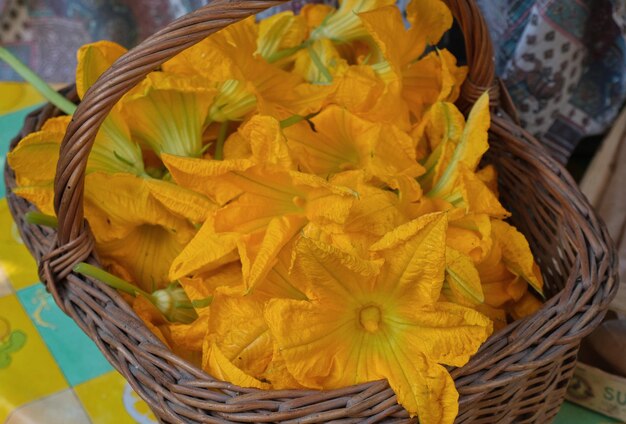 Flores de abóbora amarelas numa cesta