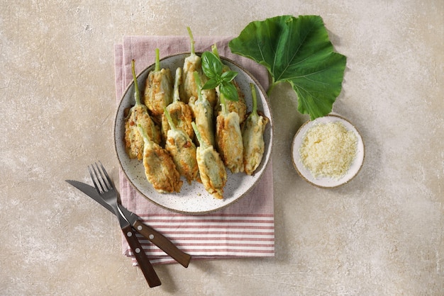 Flores de abobrinha fritas recheadas com creme de queijo servidas no prato e guardanapo saboroso prato italiano s