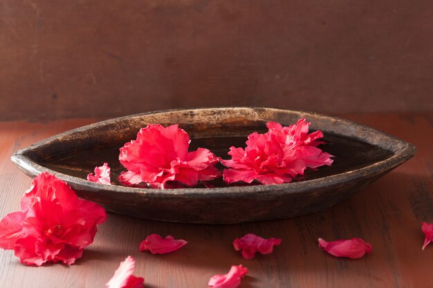 Flores de azaléia em tigela para spa de aromaterapia