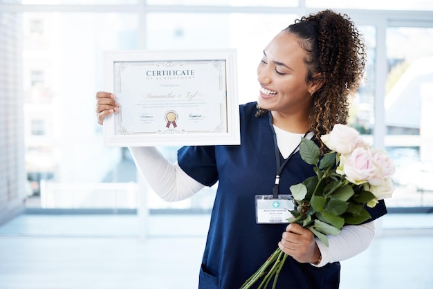 Flores de certificado e uma mulher negra graduada no hospital sentindo-se orgulhosa de sua conquista Sorria graduação e qualificação com uma jovem enfermeira feliz sozinha em uma clínica